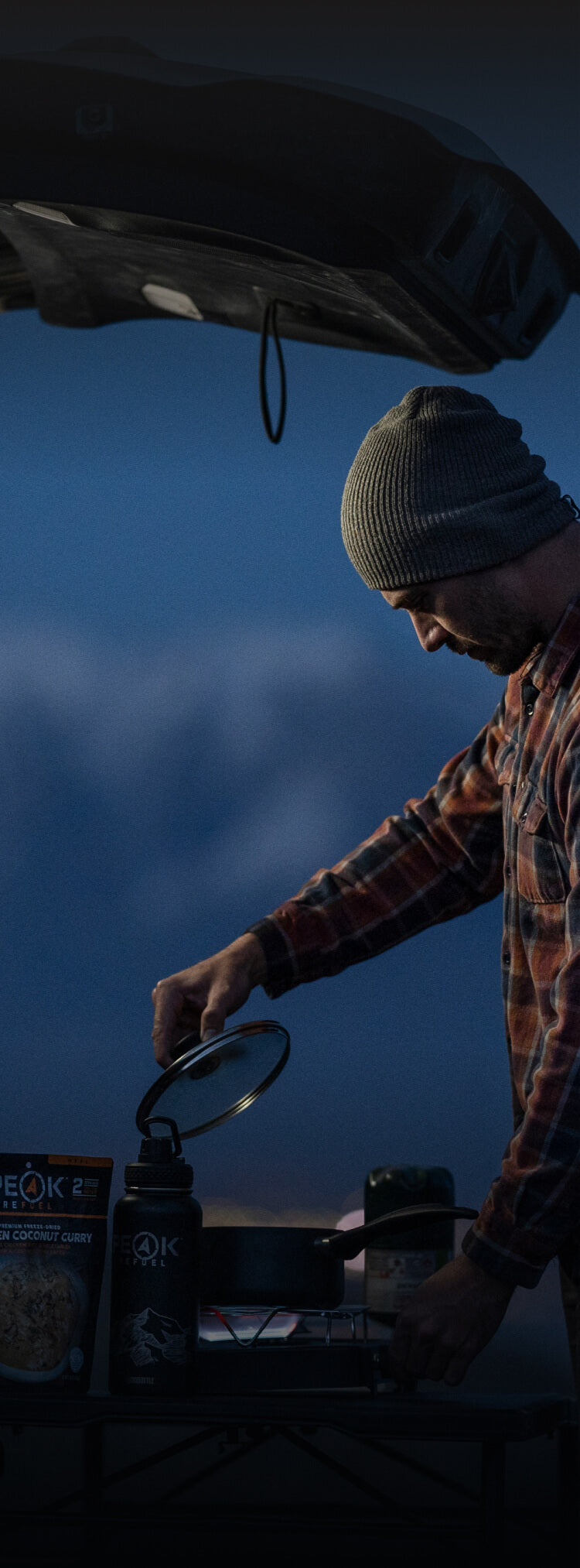 man camping at the car cooking on a camp stove