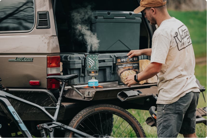 man tailgating on the back of his truck with camp stove